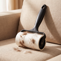 Reusable pet hair lint roller lifting pet hair from a sofa