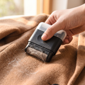 Mini lint roller being used on a wool coat