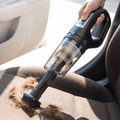 Cordless car vacuum cleaning pet hair off a car seat