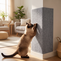Cat scratching a self-adhesive scratching mat on a wall corner